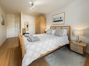 A bedroom with a bed, bedside table, lamp, and a framed picture on the wall. - 2 bedroom accommodation in Whitby (Whitby)