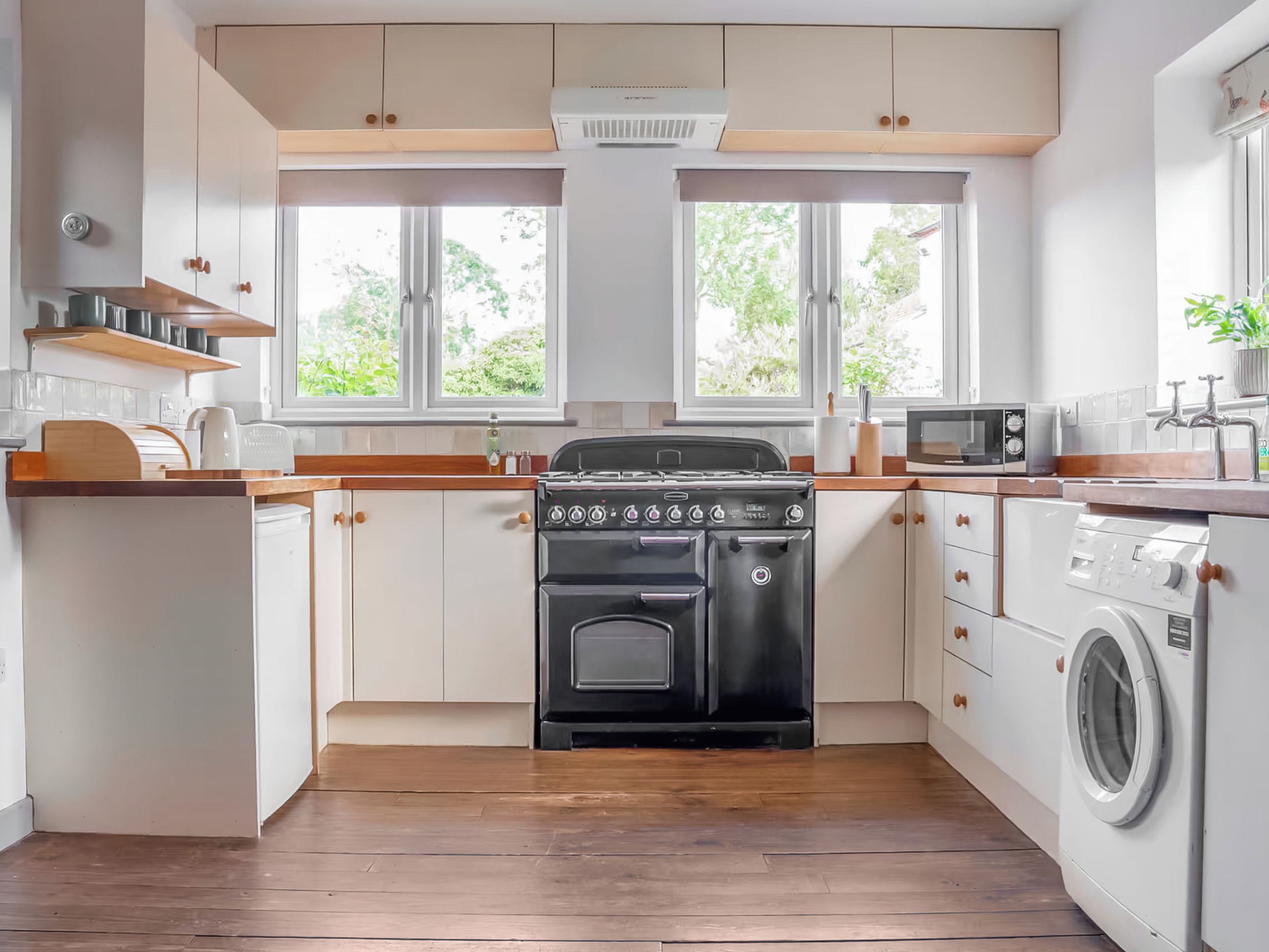 A modern kitchen with a stove, microwave, and washing machine.