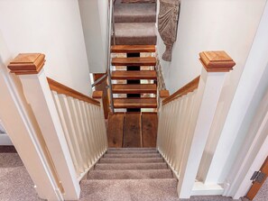 A carpeted staircase with wooden handrails and a white wall. - 5 bedroom accommodation in Long Preston (Long Preston)
