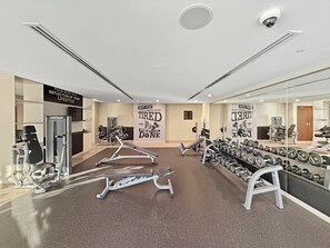 Ein Fitnessstudio mit Trainingsgeräten, einem Spiegel, motivierenden Postern und einem klaren, modernen Design.