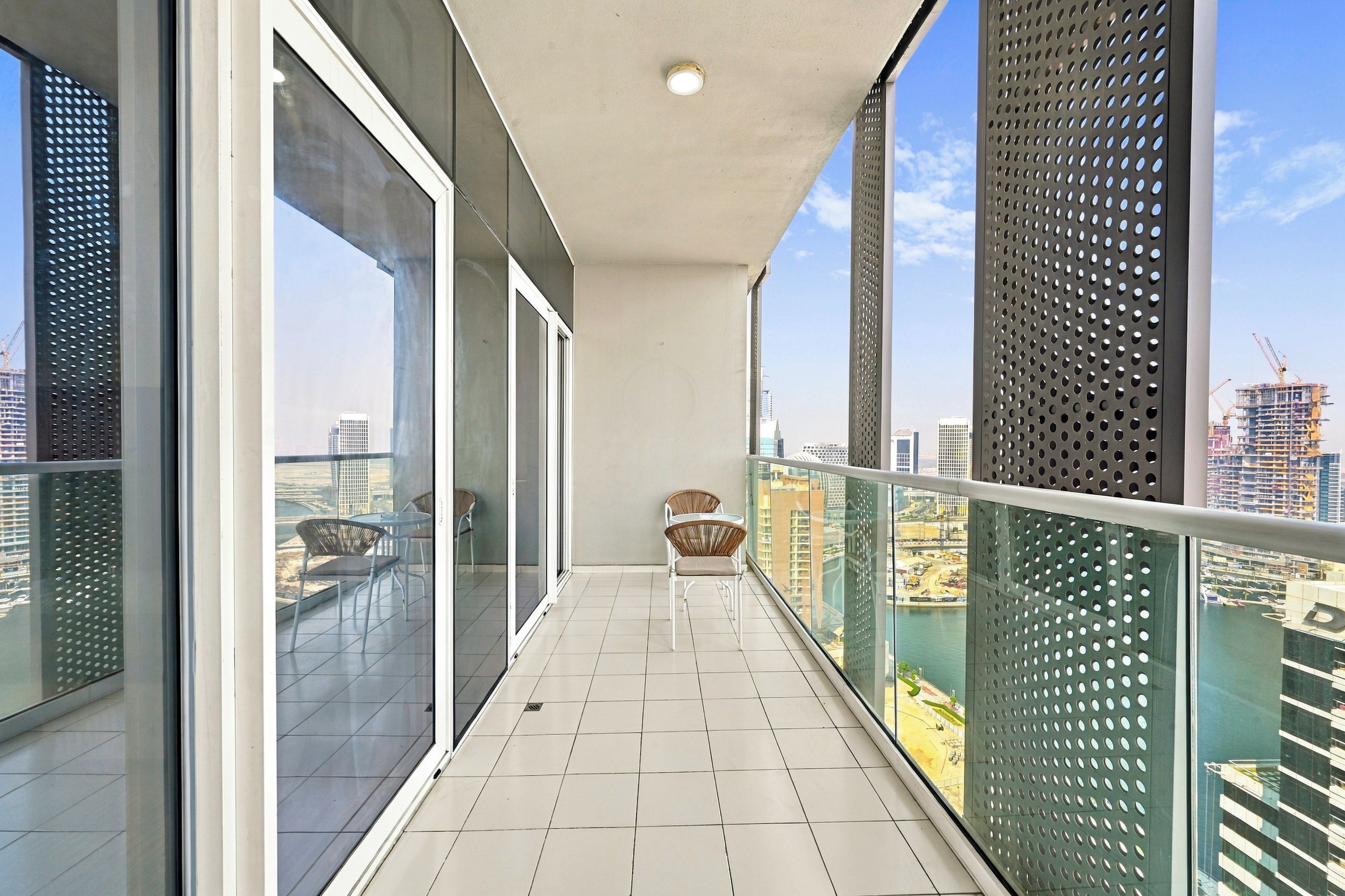 A balcony with a view of the cityscape, including buildings and construction cranes.