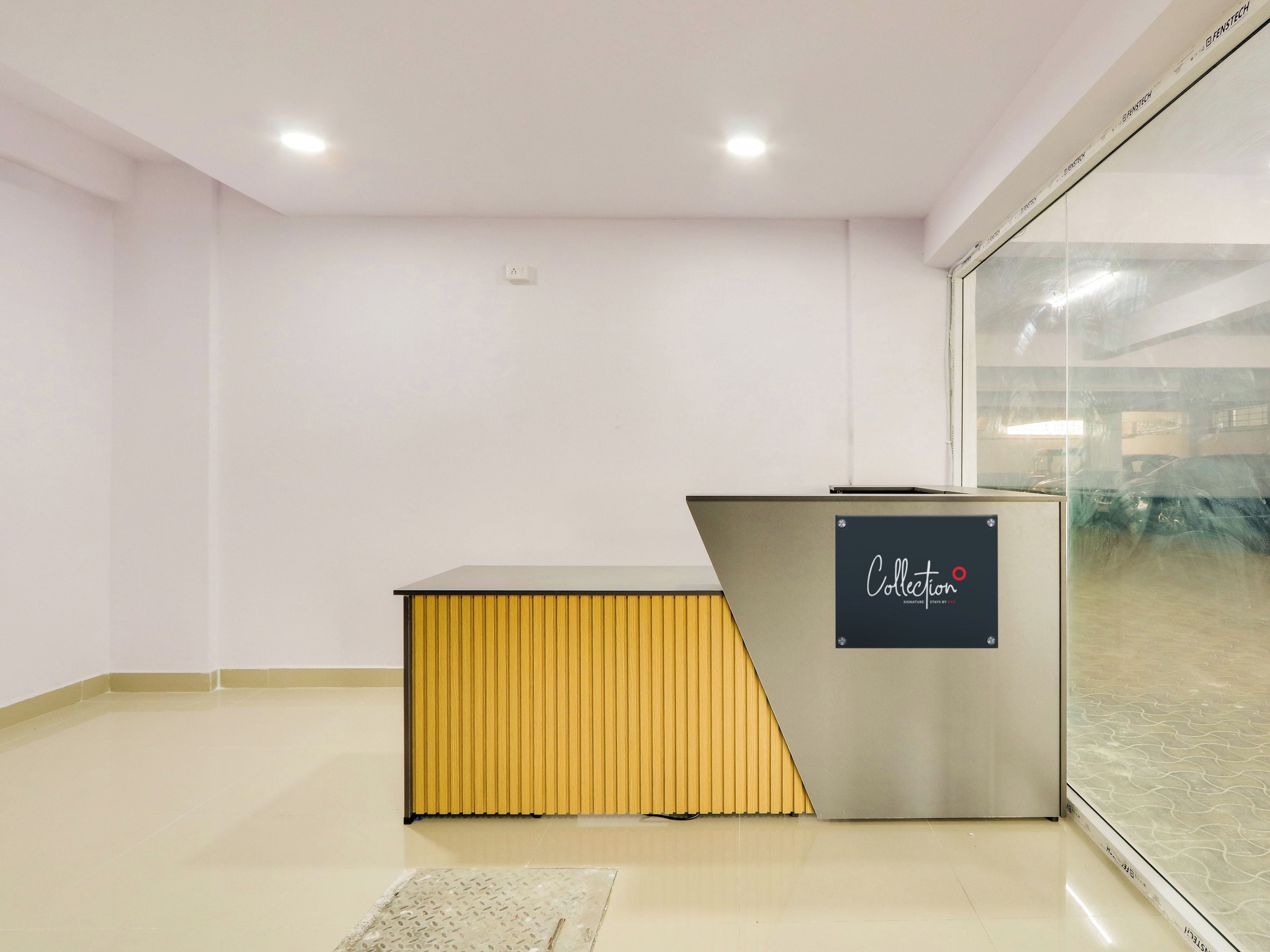 A reception area with a reception desk, a glass partition, and a tiled floor.