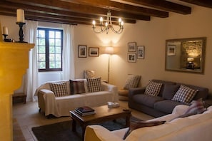 A cozy living room with a sofa, a smaller couch, a coffee table, and a fireplace. - Le pied a terre - 6 or 8 people (MONTFERRAND DU PERIGORD)