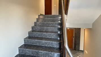 Un escalier avec une rampe métallique menant à un palier.