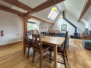 Un coin repas avec une table et des chaises en bois, un canapé et une cheminée.