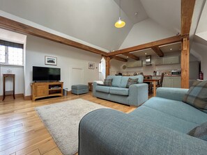 A spacious living area with a television, sofa, and wooden beams. - Valentines Cottage - UKC10038 (St Andrews)