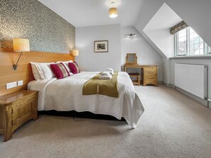 A bedroom with a bed, bedside table, lamp, dresser, and a window with a view. - The Giddy Limit Cottage - UKC10039 (St Andrews)