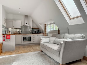 A modern kitchen with white cabinets, a built-in oven, and a skylight. - Red Squirrel Cottage Apartment - UKC10040 (St Andrews)
