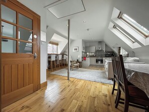 A spacious loft with a kitchen, dining area, and sleeping quarters, featuring high ceilings and skylights. - Red Squirrel Cottage Apartment - UKC10040 (St Andrews)
