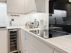 A modern kitchen with a built-in oven, stainless steel appliances, and a marble countertop. - 3 bedroom accommodation in Eyemouth (Eyemouth)