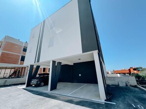A modern building with a parking area and a vehicle inside. - Spacious modern 3-bedroom apartment in beautiful Zadar with AC in every room! (Zadar)