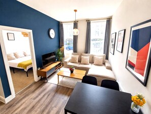 Ein modernes Wohnzimmer mit Sofa, Couchtisch und Fernseher.