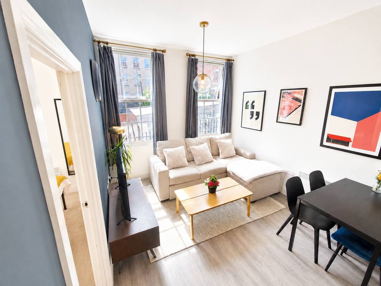 A modern living room with a sofa, coffee table, and dining area.