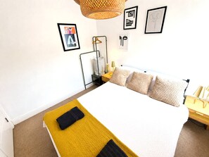 A bedroom with a bed, bedside tables, a hanging light fixture, and wall art. - Comfy Cabot Circus Central Flat | Sleeps 4 (Saint Paul's)