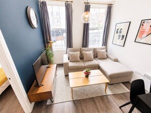 Ein modernes Wohnzimmer mit einer Couch, einem Couchtisch und einem Fernsehschrank.