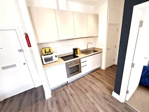 A modern kitchen with white cabinets, a stainless steel oven, and a microwave. - Comfy Cabot Circus Central Flat | Sleeps 4 (Saint Paul's)
