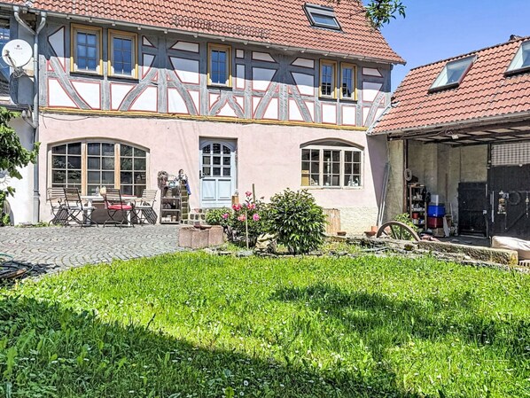 A traditional half-timbered house with a garden in front.