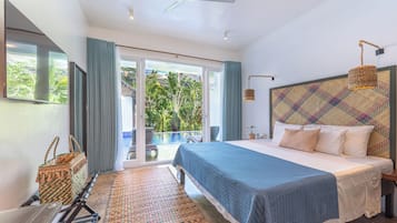 A bedroom with a large bed, a ceiling fan, a view of the outdoors, and a sliding glass door.