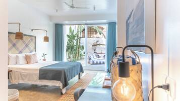 Una habitación de hotel moderna con cama, escritorio, silla, lámpara colgante y vista al exterior.