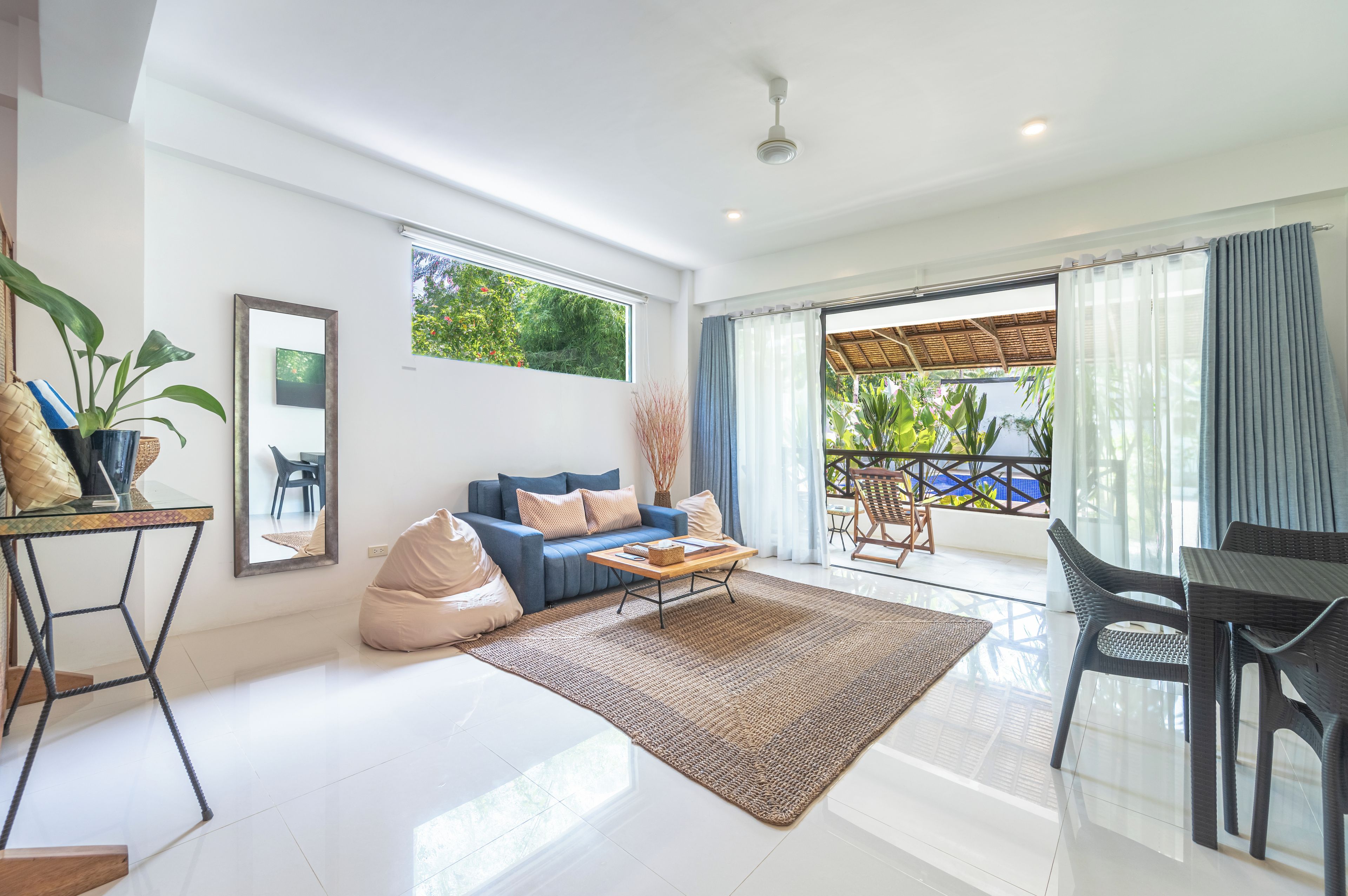 A modern living room with a sofa, coffee table, and a view to a balcony.