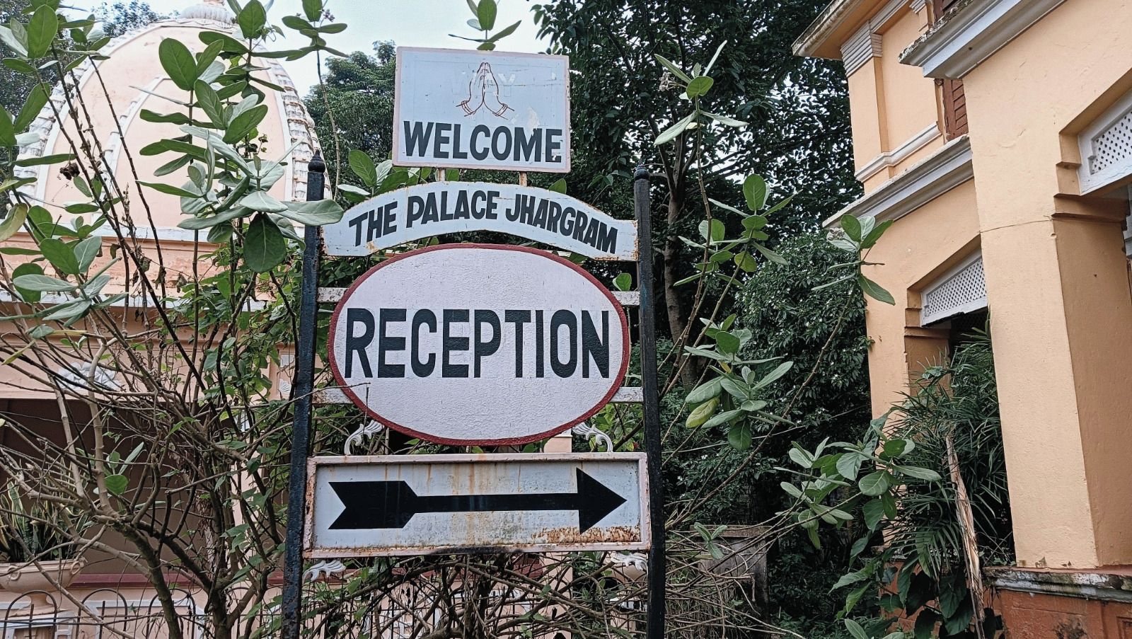 A signpost with 'WELCOME THE PALACE JHARGAM' and 'RECEPTION' indicating the direction to the reception area.