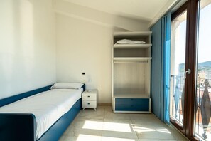 A bedroom with a bed, a nightstand, a wardrobe, and a balcony with a view. - Penthouse 'Terrazza Paradiso' (Tortolì)