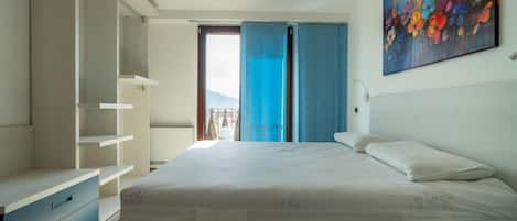 A bedroom with a bed, a wardrobe, and a painting on the wall.
