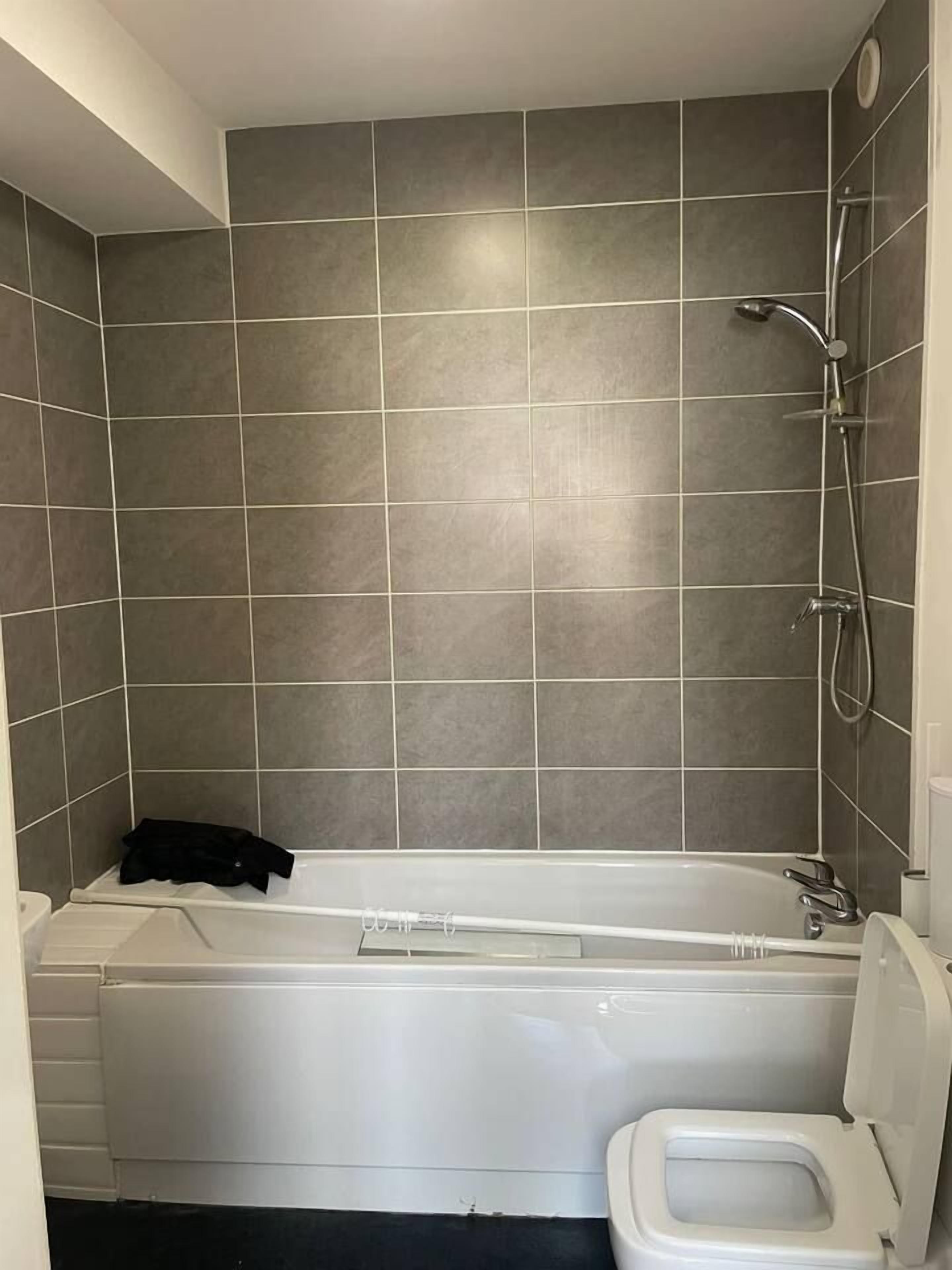 A bathroom with a bathtub, a shower, and a toilet.