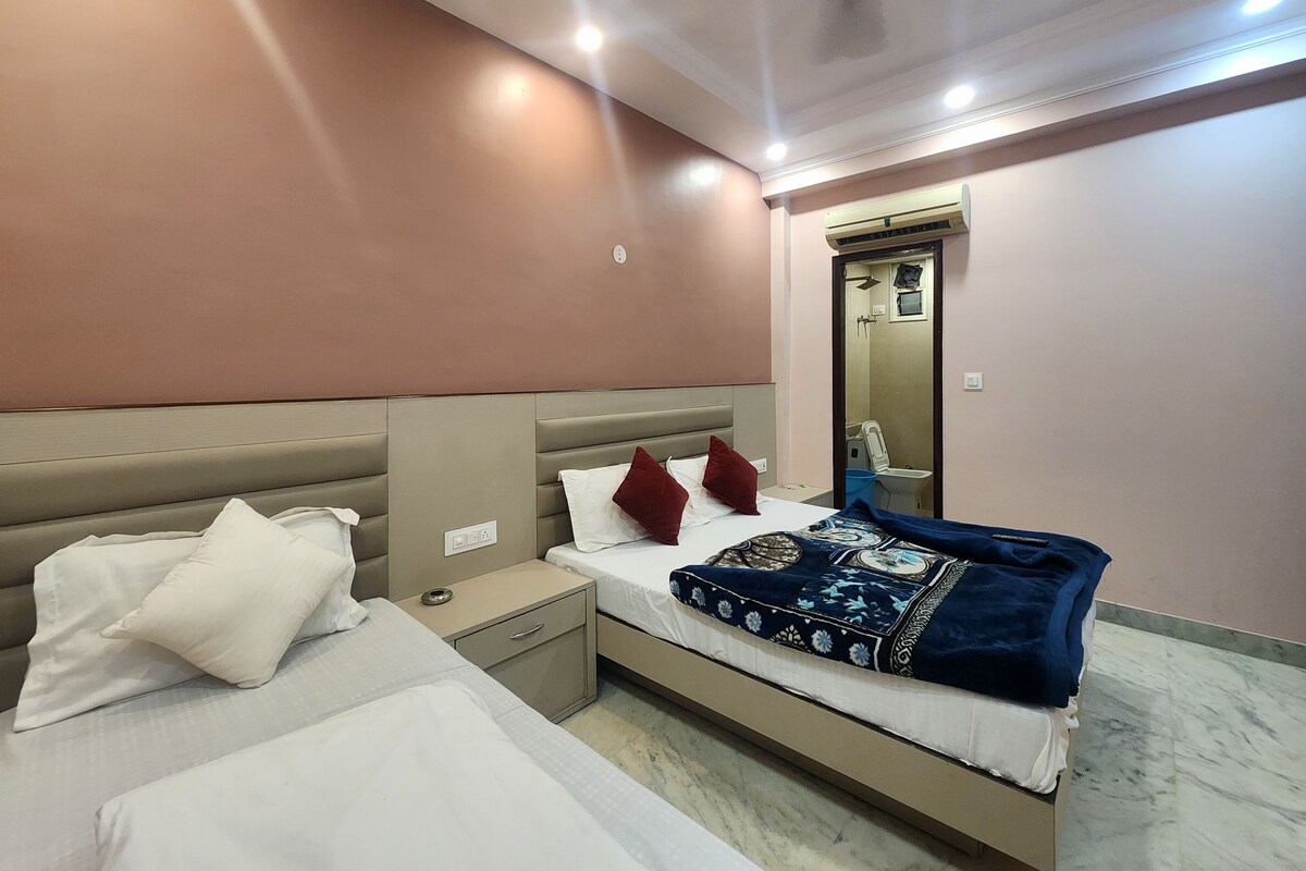 A hotel room with a bed, bedside tables, a nightstand, a mirror, and a ceiling fan.