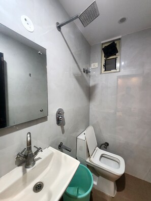 A bathroom with a sink, toilet, and shower. - Oly Hotel Heritage Inn (New Delhi)