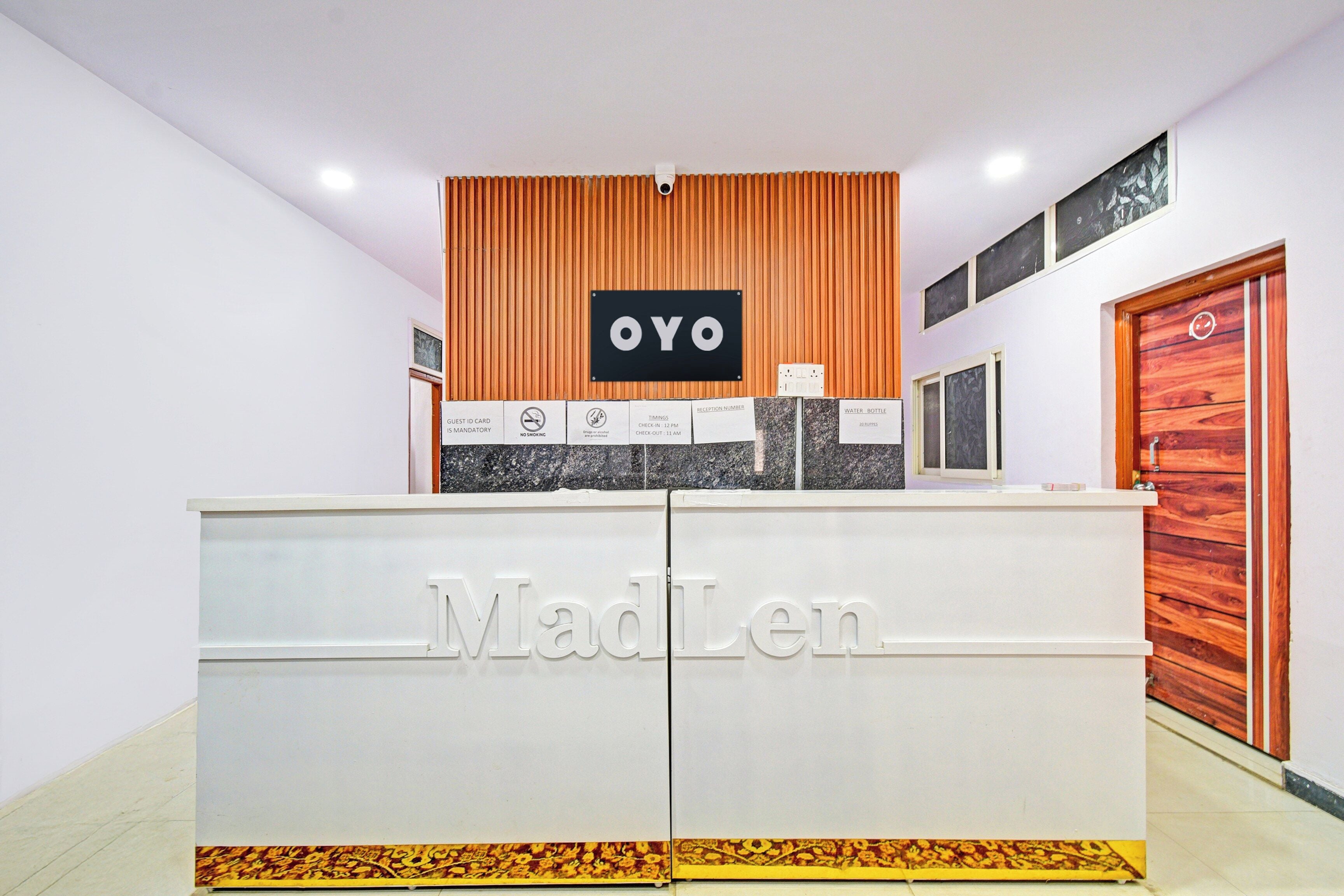 Un comptoir d’accueil avec une enseigne indiquant « MadLen » et une autre enseigne « OYO » au-dessus.