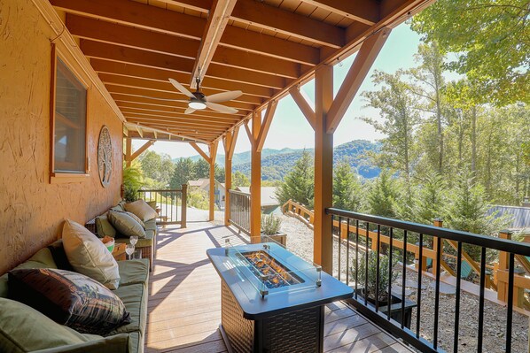 A covered outdoor seating area with a pool table, a ceiling fan, and a view of the surrounding landscape. - Mtn Views from Every Deck without The Mtn Drive! (Maggie Valley)