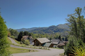 Zona residencial com casas, uma rua pavimentada e uma montanha ao fundo.