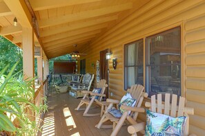 A wooden porch with several Adirondack chairs and a spinning wheel. - Mtn Views from Every Deck without The Mtn Drive! (Maggie Valley)