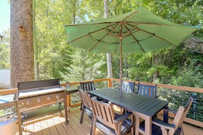 An outdoor deck with a grill, table, chairs, and an umbrella. - Mtn Views from Every Deck without The Mtn Drive! (Maggie Valley)