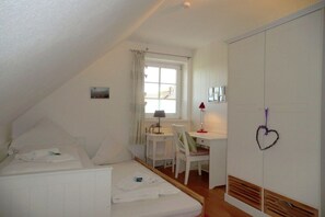 A bedroom with a bed, a desk, and a wardrobe. - Holiday home in Oevenum with swimming pool (Oevenum)