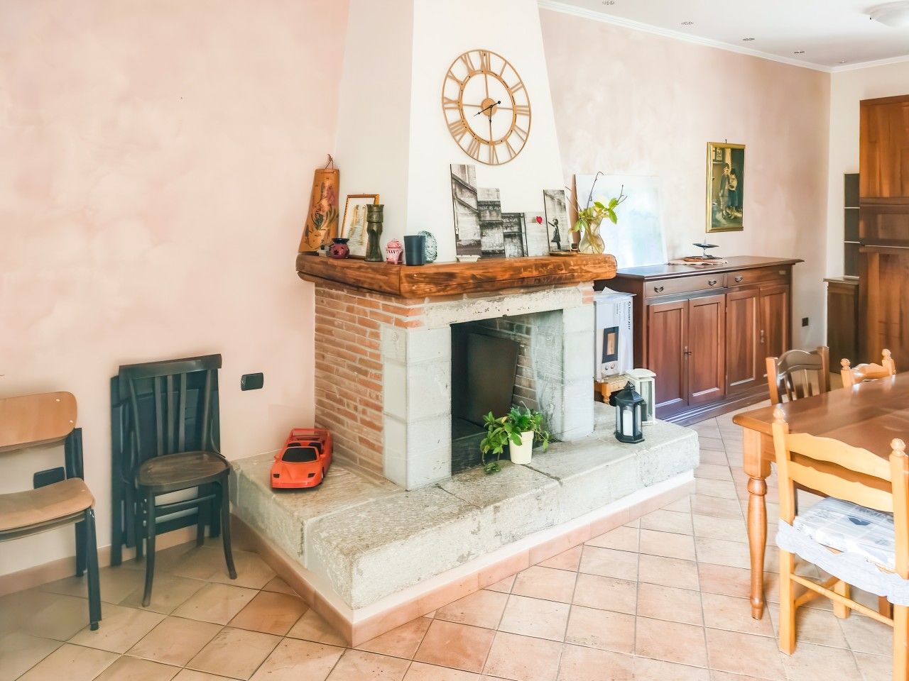 Un salon avec une cheminée, une table à manger et un buffet en bois.