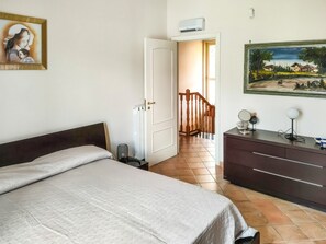 A bedroom with a bed, dresser, and a painting on the wall. - Large Family Vacation Home (Villa San Nicola)