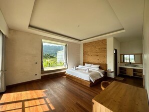 Camera da letto moderna con un letto di legno, un'ampia finestra e vista sul verde.