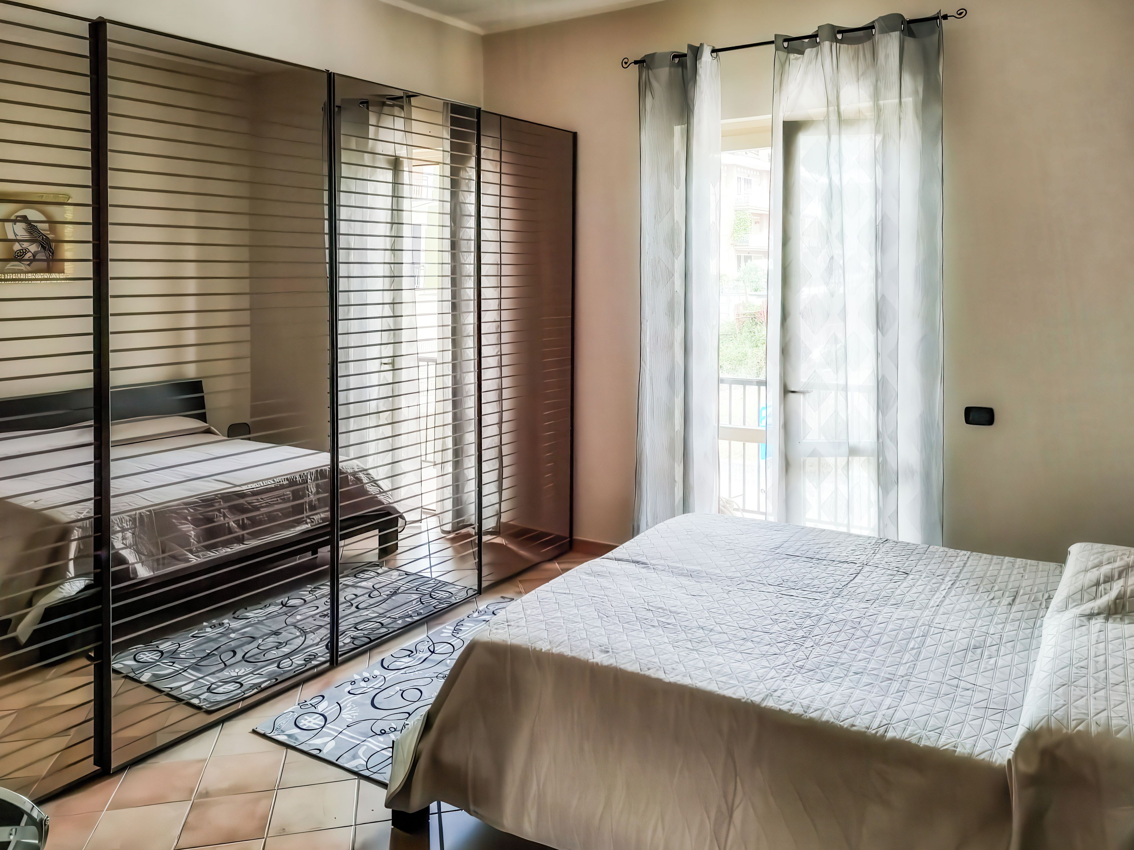 Une chambre avec un lit, un canapé, une porte coulissante et une vue sur l’extérieur.
