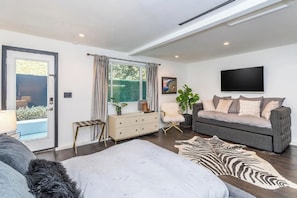 A modern living room with a sofa, a zebra rug, and a television. - Oakfield Rise (Sherman Oaks)