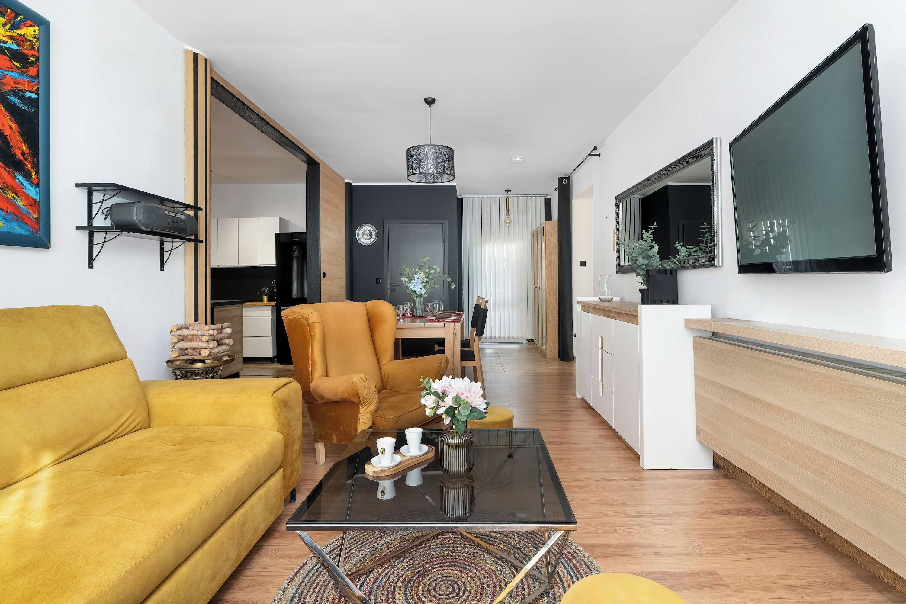 A modern living room with a sofa, a coffee table, and a dining area with a chair and table.