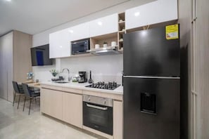 Eine moderne Küche mit einem Edelstahl-Kühlschrank, Backofen und Mikrowelle.