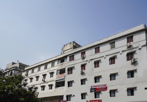 Un edificio de varios pisos con letreros para un hotel, una clínica oftalmológica y una tienda móvil.