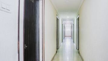 Un pasillo largo y estrecho con puertas a ambos lados, que conduce a habitaciones individuales.