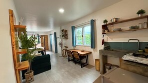 Una cocina moderna con zona de comedor, muebles de madera y vistas al exterior.