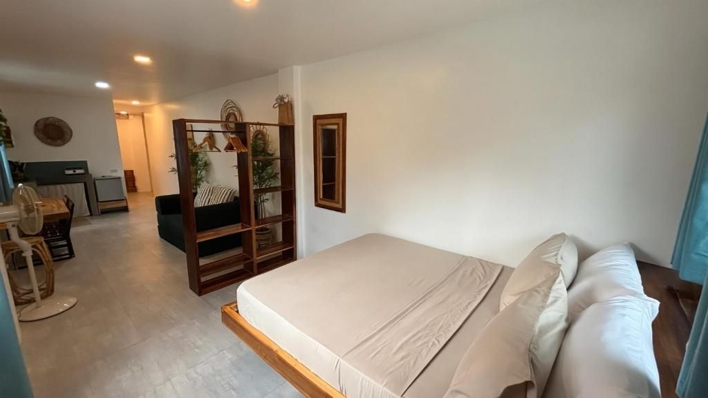 Een slaapkamer met een bed, een houten hoofdbord, een nachtkastje en een spiegel.