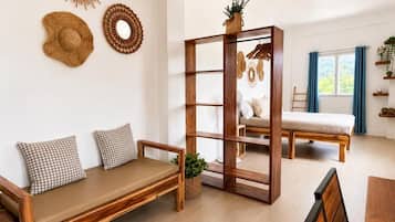 A modern living room with a wooden sofa, a wooden bench, a wooden bookshelf, and a dining table.