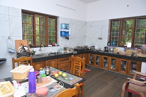 A kitchen with marble tiles, wooden cabinets, and a large window.