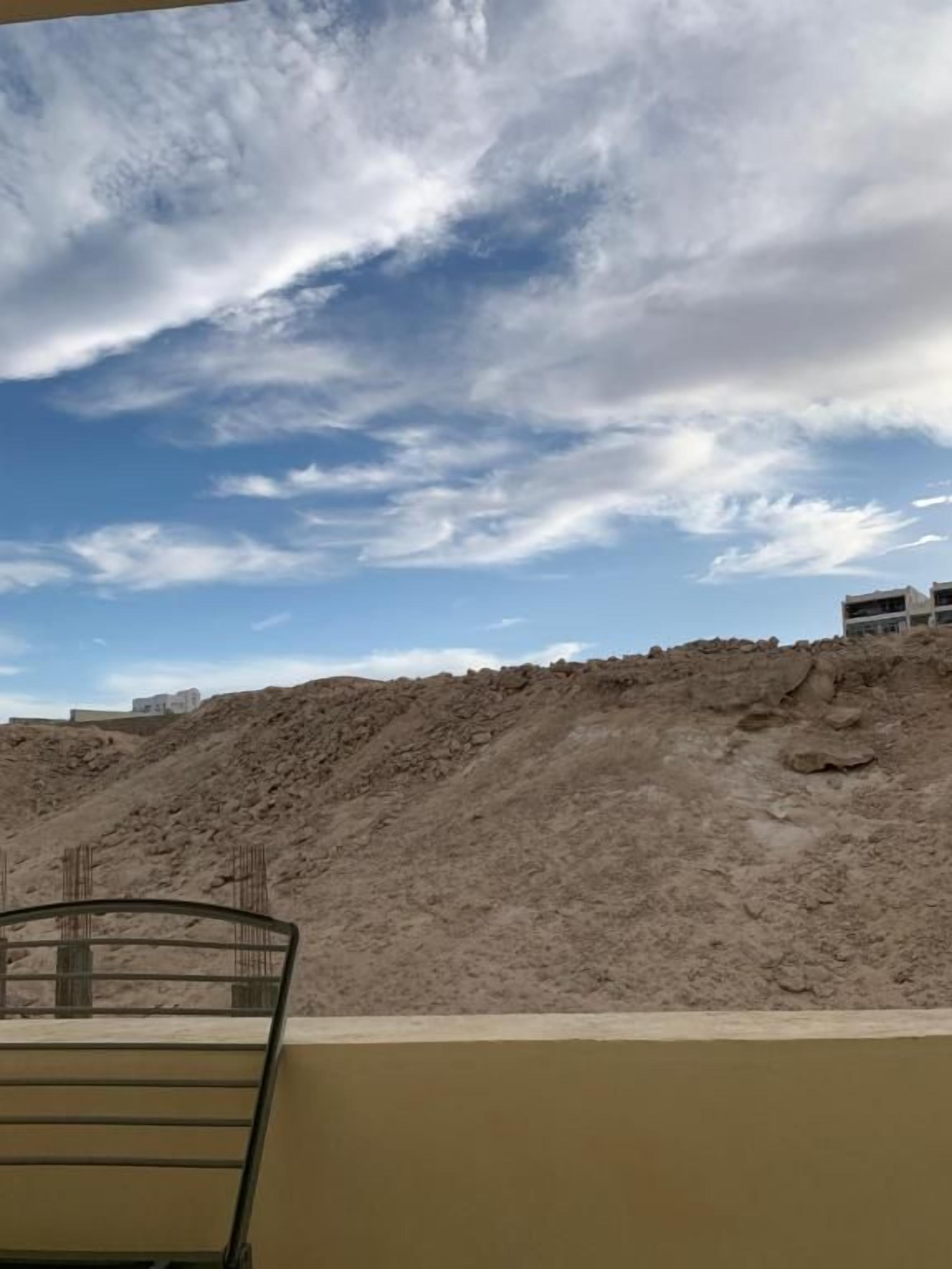 Eine Baustelle mit Metallzaun und blauem Himmel.